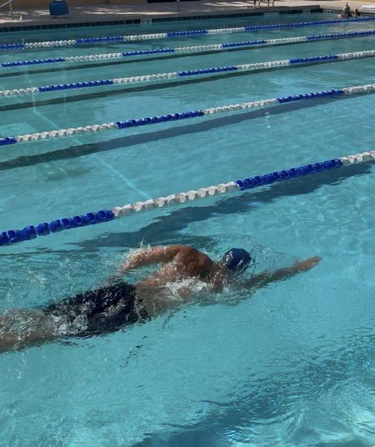 Swimmer mid-stroke in a lap pool